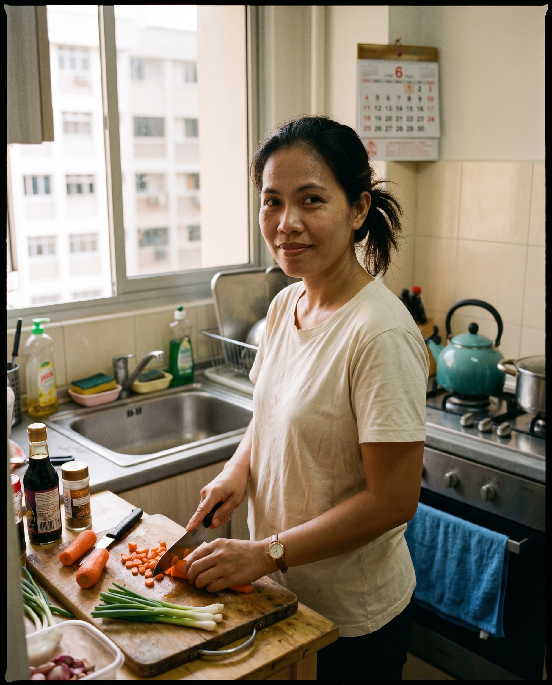 A domestic helper preparing dinner at the kitchen counter of a Singapore HDB home.